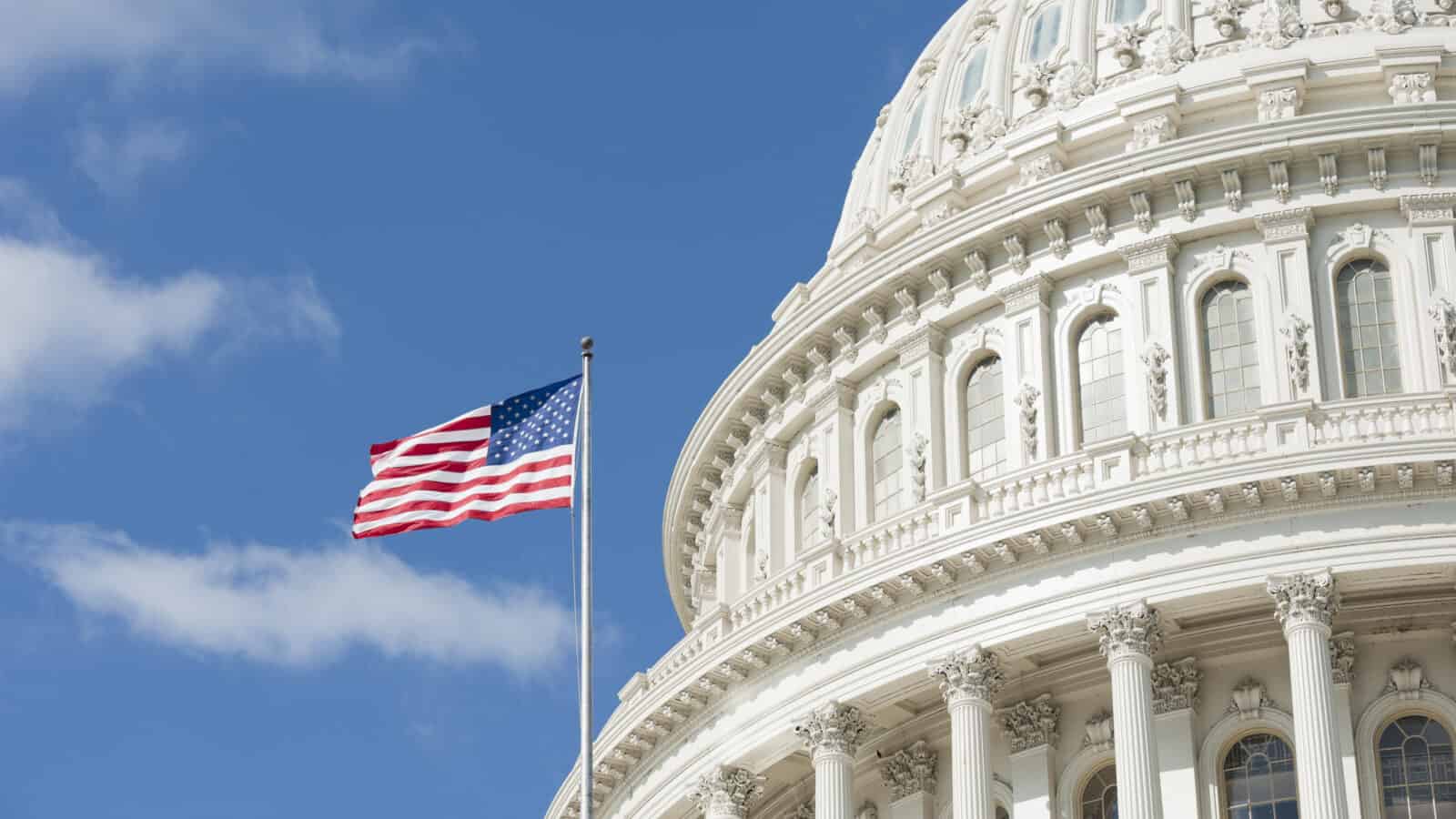 American flag waving in front of Capitol Hill